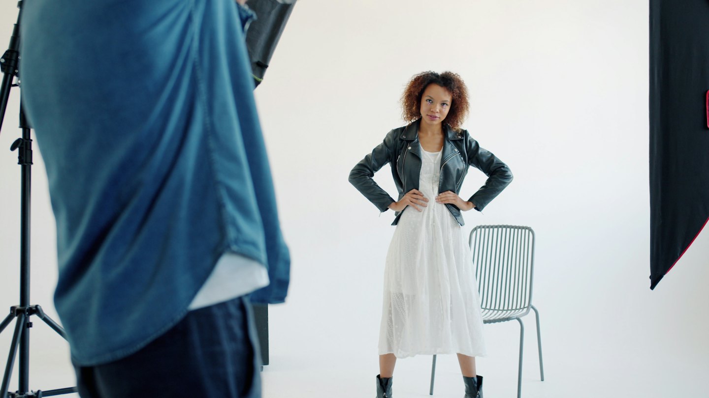 Fotograf macht Foto von Model im Studio.