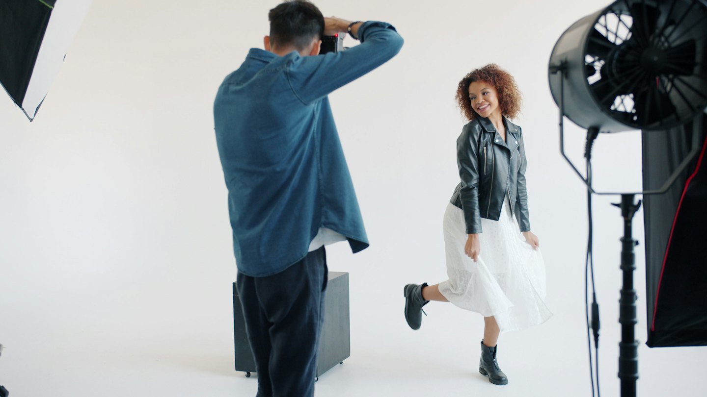 Modell posiert für Fotograf in hellem Studio.